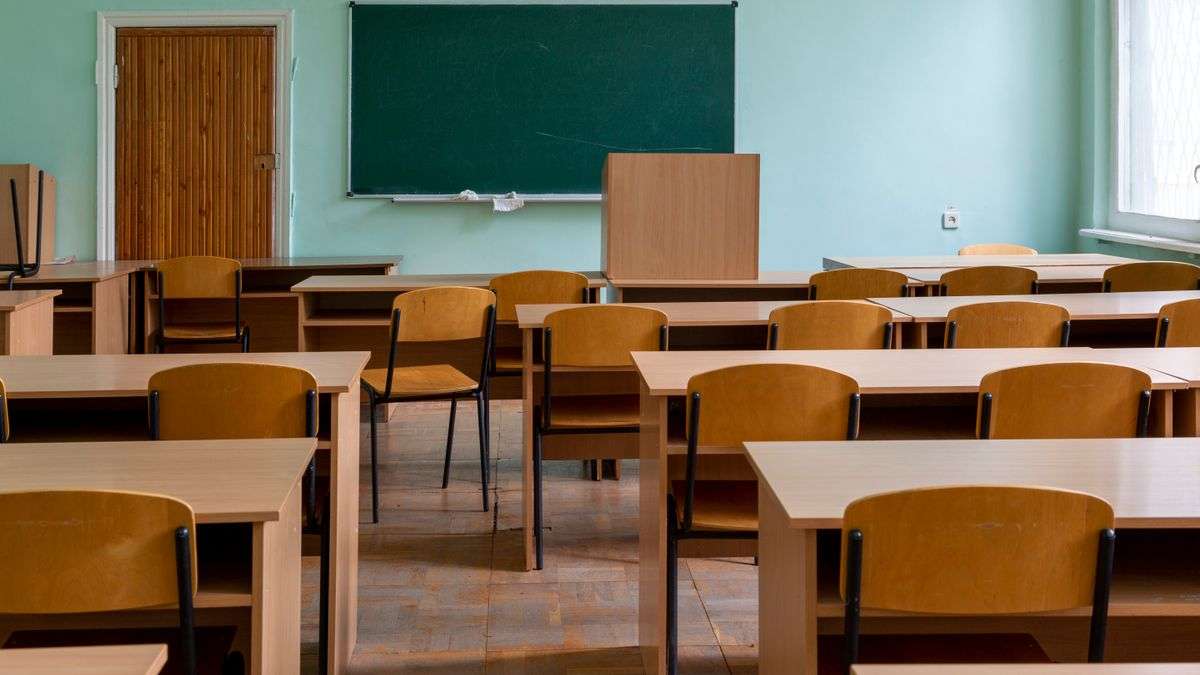 An empty classroom with desks and a chalkboard